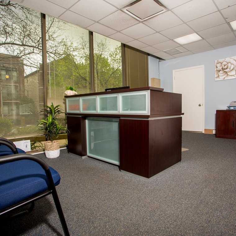 Office with printer, blue chairs and dark wood desk inlayed with frosted glass  tiles